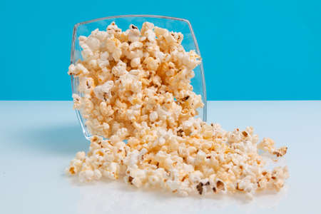 popcorn in a glass bowl on blue backgroundの写真素材