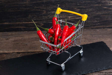 red chili pepper in shopping cart on tableの写真素材