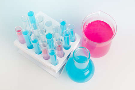 Test tubes and flasks with liquid on a white table. View from above.の写真素材