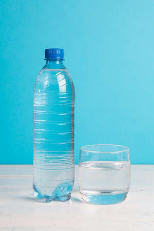 Plastic bottle of healthy water and glass with waterの写真素材