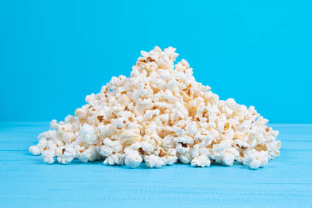 scattered popcorn on a blue table close upの写真素材