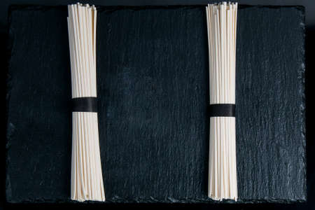 Raw asian udon noodles on black table with copy space