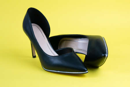 Women black classic shoes on a yellow backgroundの写真素材