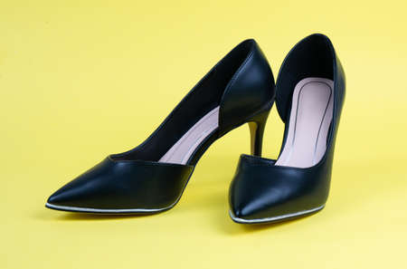 Women black classic shoes on a yellow backgroundの写真素材