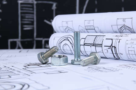 Wrench, bolts and nuts on background of engineering drawings. Science, mechanics and mechanical engineeringの写真素材