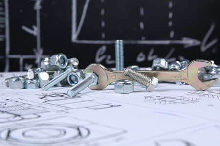 Wrench, bolts and nuts on background of engineering drawings. Science, mechanics and mechanical engineeringの写真素材