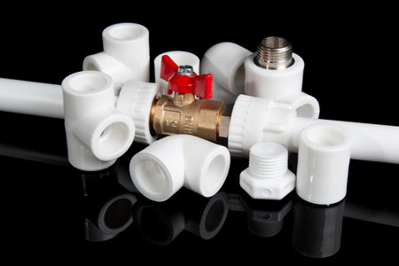 plumbing fittings for plastic pvc pipes and plumbing gate ball vales on black backgroundの写真素材