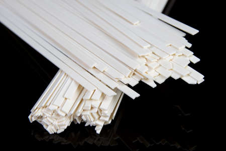 Uncooked chinese and japanese udon noodles on black tableの写真素材