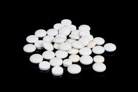 white medical pills and antibiotics on black tableの写真素材