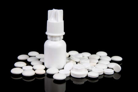 white medical pills and nasal drops for pills on black backgroundの写真素材