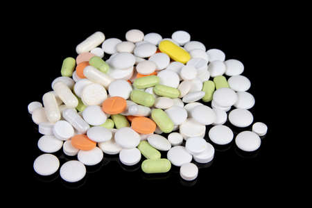 colored medical drugs and pills on black tableの写真素材