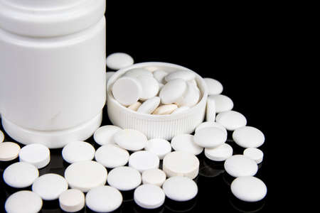 colored medical drugs and pills on black table
