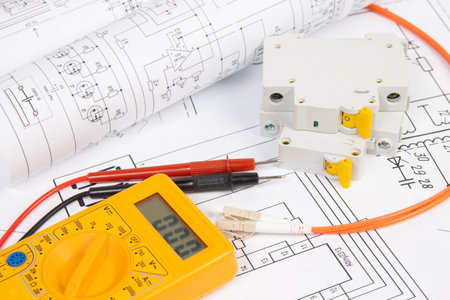Paper electrical engineering drawings with circuit breaker and multimeter.の写真素材