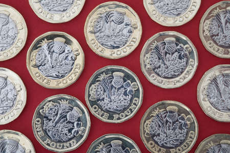 New british pound coins on red backgroundの写真素材