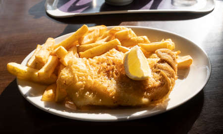 Fish and chips on a plate, battered cod with french fries is traditional british fast food.の写真素材