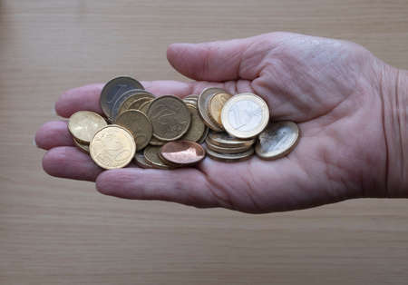 Hand holding lots of euro coins, the currency of the EUの写真素材