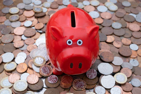 Piggy bank on background of uk coins, savings or budget conceptの写真素材