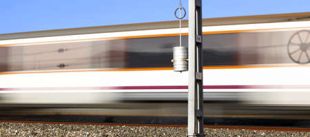 Train in movement with post and blue skyの写真素材