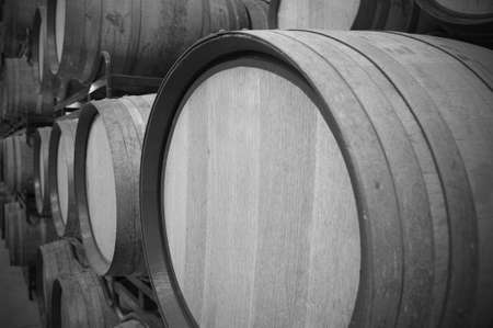 Wine barrels in an aging process at spanish cellar black and white