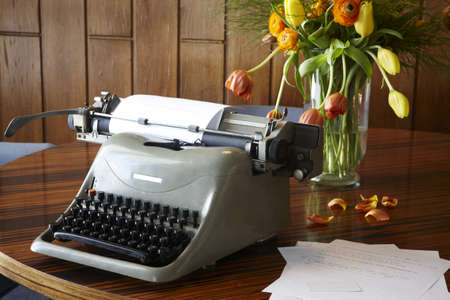 Old typewriter on table still life with flowers and wood backgroundの写真素材
