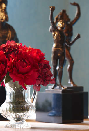 Branch of red flowers with decoration figures in the background verticalの写真素材