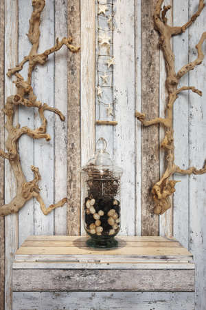 Household decoration elements with branches of tree and starfishes against wood painted background verticalの写真素材