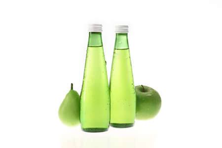 Apple and pear with bottling fruits ingredients refreshment drinks against white backgroundの写真素材