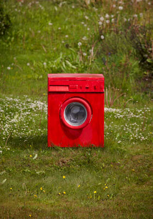 Red painted washing machine on the gound の写真素材