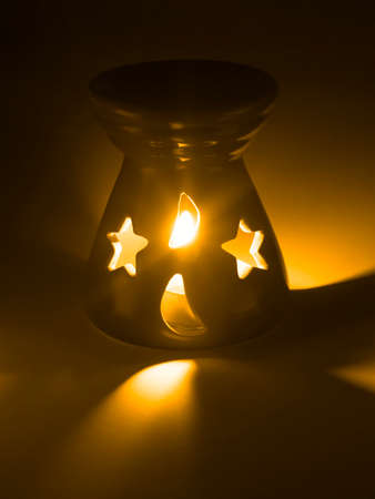 Household ceramic ornament with burning candle inside verticalの写真素材