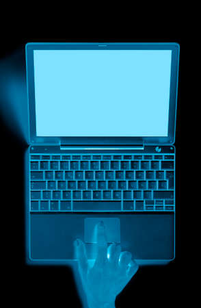 Portable computer with hand and blue tones  Verticalの写真素材