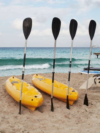 Paddles and kayaks on a mediterranean beach  Horizontal