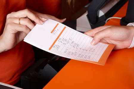 Bet ticket with male and female hands  Horizontalの写真素材