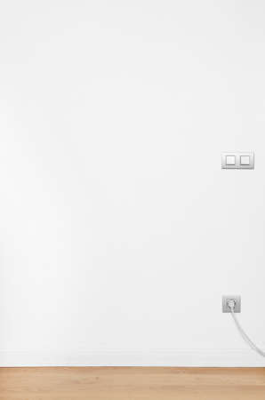 White wall with wooden floor and socket  Vertical formatの写真素材