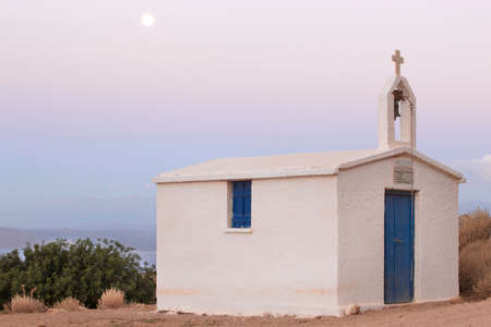Greek chapel at sunset with full moon. Horizontal. Creteの写真素材