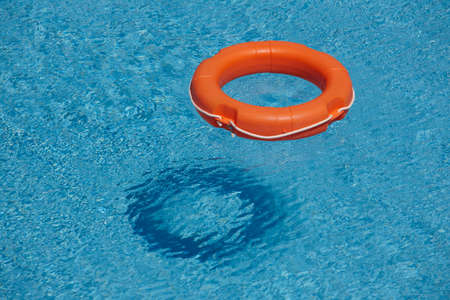 Orange life rings in blue water.
