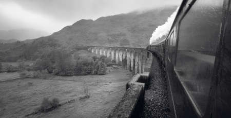 Scottish steam train passing a classic bridge. Horizontalの写真素材