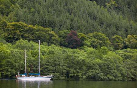 Caledonian canal with sailboat and forest in Scotland. Horizontalの写真素材