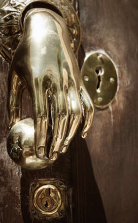 Golden doorknob detail on a wooden door in Spain. Verticalの写真素材