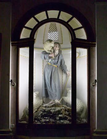 Christ sculpture with sheep in a glass case. Verticalのeditorial素材