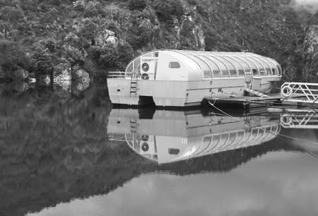 Touristic river barge with transparent all weather roof ceiling at the dockの写真素材