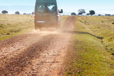 Dirty road in a mediterranean meadow with minibus. Cabaneros. Spain. Horizontalの写真素材