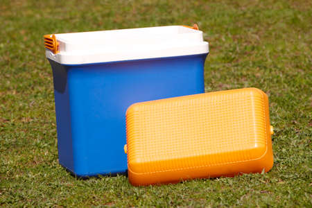 Picnic cooler in the grass in blue and orange tone. Horizontalの写真素材