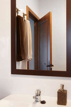 Mirror and towels detail in a bathroom with white walls. Verticalの写真素材