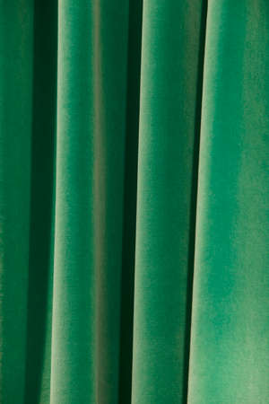 Green curtains with waves and shadows detail. Verticalの写真素材
