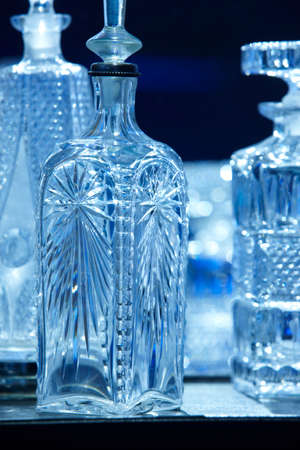 Empty crystal bottles for liquor in blue tone. Verticalの写真素材