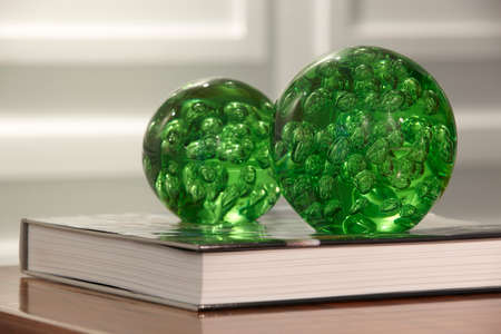 Green spheres with bubbles over a book in a room. Horizontalの写真素材