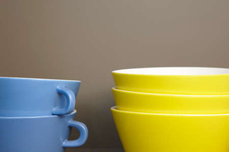 Blue cups and yellow bowls detail with grey background. Horizontalの写真素材