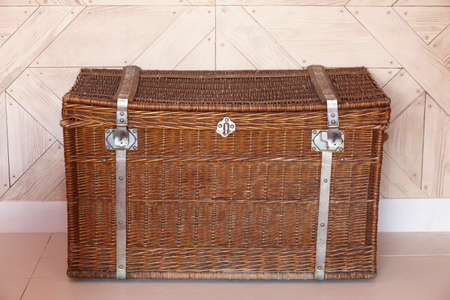 Wicker chest with locks in a room with wooden walls. Horizontalの写真素材