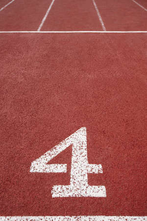 Number four signpost in an athletic running track. Vertical