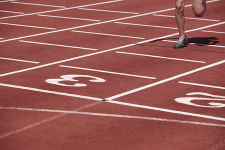 Male runner finalizing a race in a running track. Horizontal